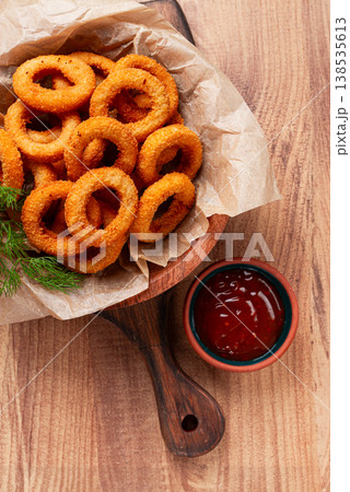 Deep fried onion rings, appetizer, with tomato sauce, on a wooden table, no people, favorite dish, 138535613