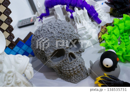 3D printed different art objects. Objects printed on 3D printer from melted colored plastic. Model gray skull created on 3D printer from threads of molten plastic. Modern new additive technologies 138535731