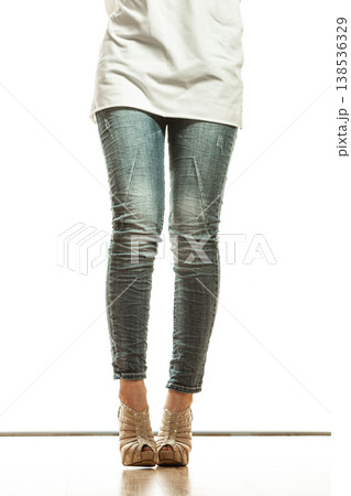 woman legs in denim trousers high heels shoes 138536329