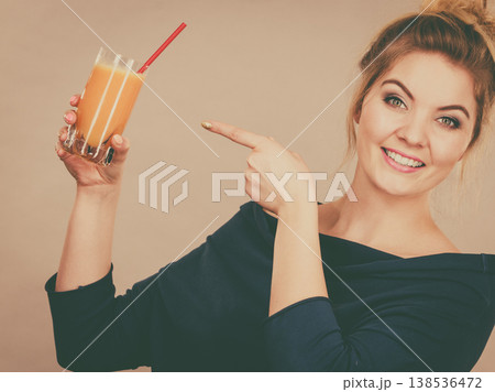 Happy woman holding fresh orange juice Happy woman holding fresh orange juice 138536472