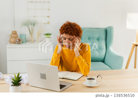 African woman touching temples experiencing stress. Girl at home office tired of working feeling headache sick rubbing temples forehead. Long laptop usage computer vision syndrome. Office syndrome African woman touching temples experiencing stress. Girl at home office tired of working feeling headache sick rubbing temples forehead. Long laptop usage computer vision syndrome. Office syndrome 138536510
