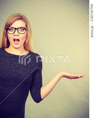 Nerdy woman in eyeglasses being confused 138536709