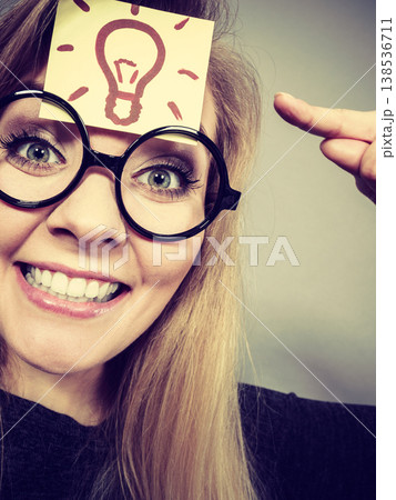 Woman having light bulb mark on forehead thinking Woman having light bulb mark on forehead thinking 138536711
