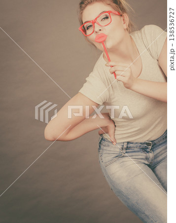 Happy woman holding fake lips on stick Happy woman holding fake lips on stick 138536727