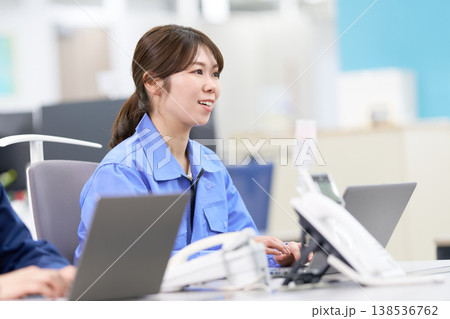 作業着でデータ入力を行う笑顔の女性スタッフ 138536762