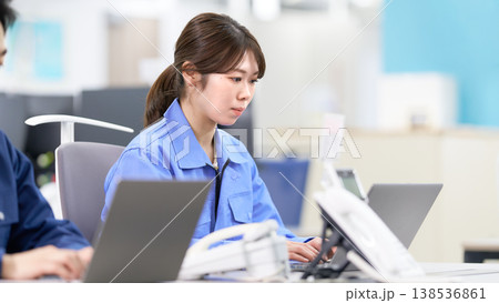 作業着でデータ入力を行う工場スタッフの仕事風景 138536861