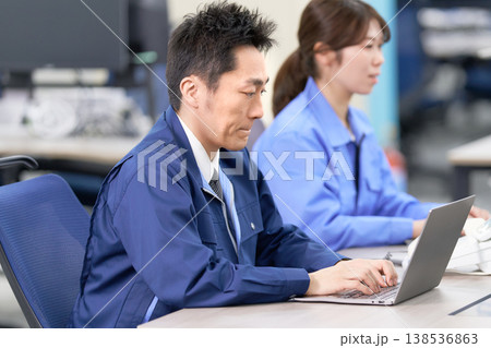 作業着でデータ入力を行う工場スタッフの仕事風景 138536863