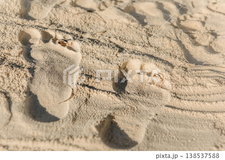 Wedding rings placed in footprint on sandy beach Wedding rings placed in footprint on sandy beach 138537588