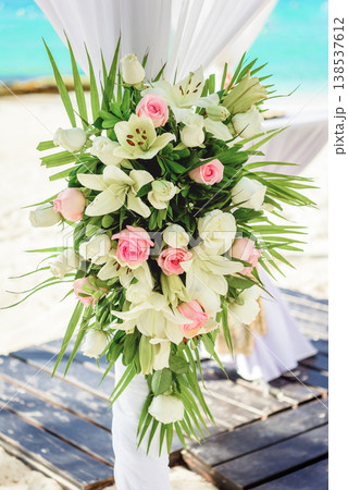 Elegant tropical wedding floral arrangement on beach arch Elegant tropical wedding floral arrangement on beach arch 138537612
