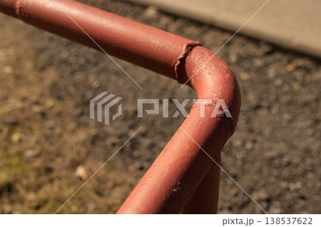 Close-up of a red metal water pipe with a welded joint. Industrial plumbing infrastructure Close-up of a red metal water pipe with a welded joint. Industrial plumbing infrastructure 138537622