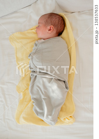 Newborn baby sleeping peacefully on a soft yellow blanket at home. Cozy natural light, calm atmosphere and tender early childhood moment. Concept of parenting and newborn care. Newborn baby sleeping peacefully on a soft yellow blanket at home. Cozy natural light, calm atmosphere and tender early childhood moment. Concept of parenting and newborn care. 138537633