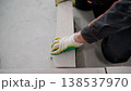 A construction worker's gloved hand laying an autoclaved aerated concrete block to build an interior wall. 138537970