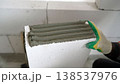 Worker applying glue adhesive on aerated concrete block at construction site. 138537976