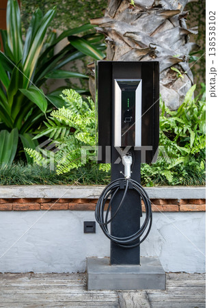Hi-tech charging station with electronic display arranged on street for electric vehicle EV car. Hi-tech charging station with electronic display arranged on street for electric vehicle EV car. 138538102