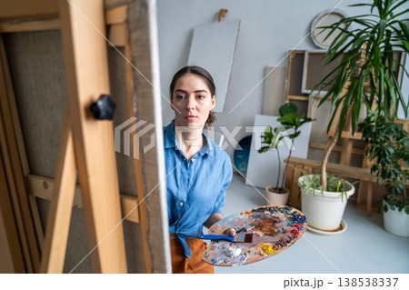 Concentrated woman artist dedicated art lover painting picture in loft studio, art hobby therapy. 138538337