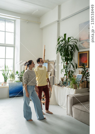 Married artists couple looking at wall paintings exhibition together at home gallery studio workshop Married artists couple looking at wall paintings exhibition together at home gallery studio workshop 138538449