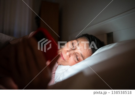 Senior woman falling asleep with smartphone in hands, unhealthy phone addiction and time wasting. Senior woman falling asleep with smartphone in hands, unhealthy phone addiction and time wasting. 138538518