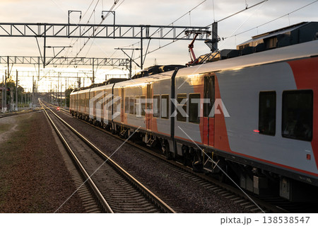 Express train leaves station reaching new destination to pick up and drop off passengers at sunset 138538547