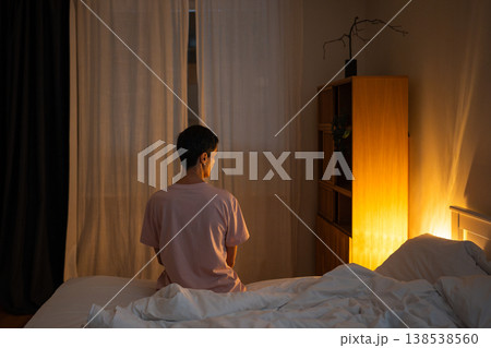 Thoughtful lonely senior woman sitting in bed late at night reflecting on life problems and worries. Thoughtful lonely senior woman sitting in bed late at night reflecting on life problems and worries. 138538560