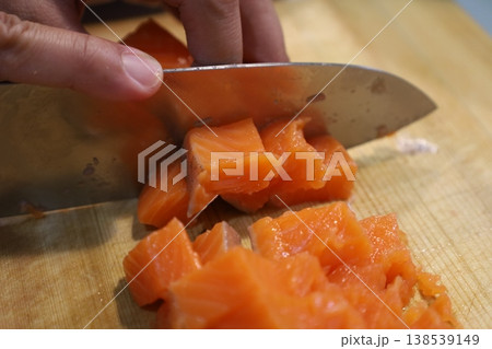 サーモンを包丁でさいの目切りにする調理シーン まな板クローズアップ サーモンを包丁でさいの目切りにする調理シーン まな板クローズアップ 138539149