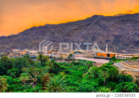 A beautiful sunset over the mountains and lush palm groves surrounding Thee Ain village in the Al Bahah region of Saudi Arabia. A beautiful sunset over the mountains and lush palm groves surrounding Thee Ain village in the Al Bahah region of Saudi Arabia. 138539335