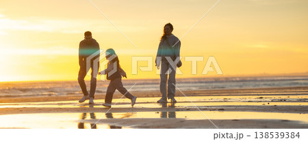 Family enjoying walking on beach at beautiful sunset 138539384