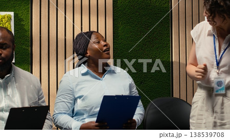 African american female candidate getting called in the HR office for interview, awaiting discussion and showcasing anticipation in office. Applicants within the recruitment process. 138539708
