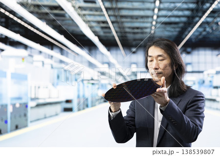 Asian man analyzing semiconductors substrates architecture, upgrading design. Senior manager examining advanced silicon wafer electronic equipment, doing production quality control Asian man analyzing semiconductors substrates architecture, upgrading design. Senior manager examining advanced silicon wafer electronic equipment, doing production quality control 138539807