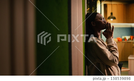 African american pious woman praying and meditating at home, showing belief and devotion to God. Hands together to communicate with Jesus Christ through religious connection and hope. 138539898