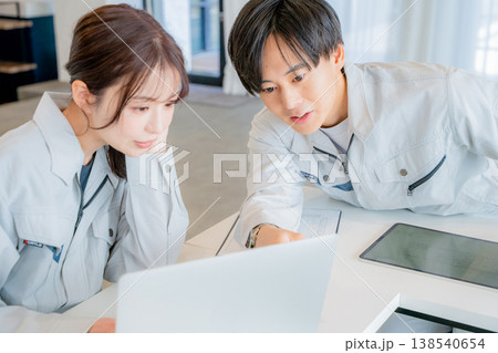 ミーティングをする作業服の男女 138540654