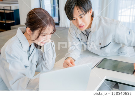 ミーティングをする作業服の男女 138540655