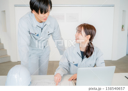 ミーティングをする作業服の男女 138540657
