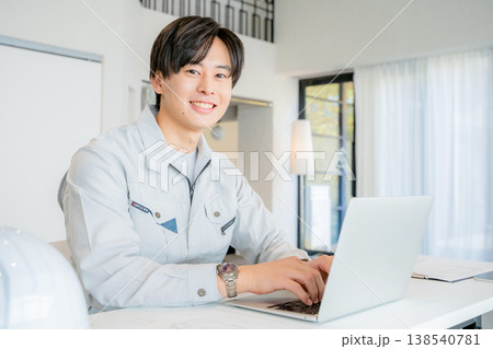 デスクワークをする作業着の男性 138540781