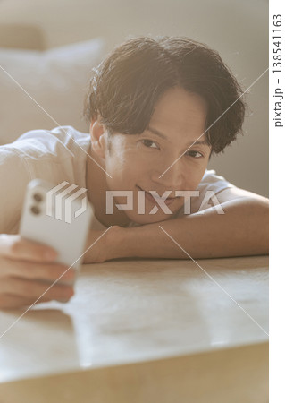 笑顔でスマホを使う若い男性 笑顔でスマホを使う若い男性 138541163