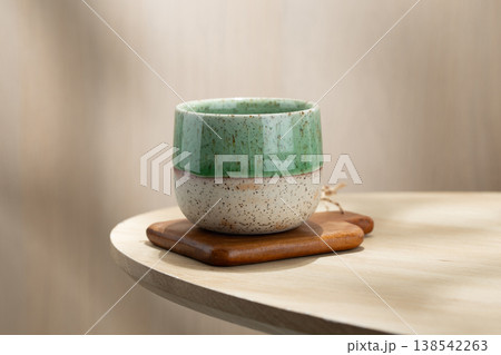 Japanese Style Ceramic Tea Cup on Wooden Coaster with Soft Natural Light Japanese Style Ceramic Tea Cup on Wooden Coaster with Soft Natural Light 138542263