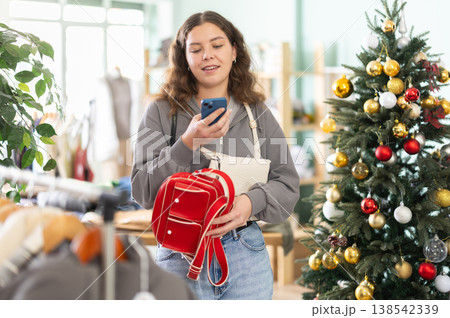Woman scanning mobile barcode on bag with Christmas tree background Woman scanning mobile barcode on bag with Christmas tree background 138542339