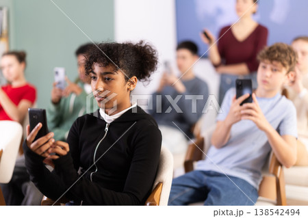 Teenage girl using smartphone to scan QR codes during lesson 138542494