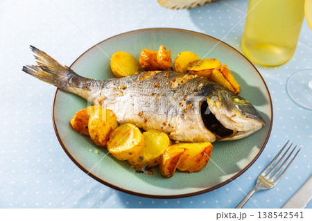 Baked fish called Dorada with toasted potatoes 138542541