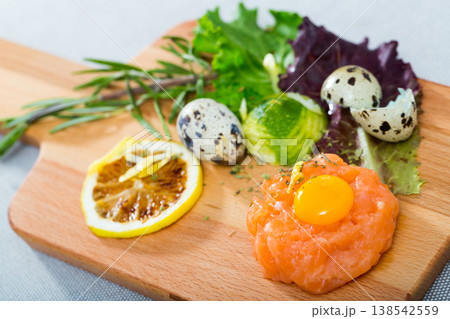 Tartar of salmon with balsamic, greens, lemon and quail egg Tartar of salmon with balsamic, greens, lemon and quail egg 138542559