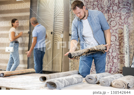 On territory of exhibition hall, guy inspect carpets 138542644