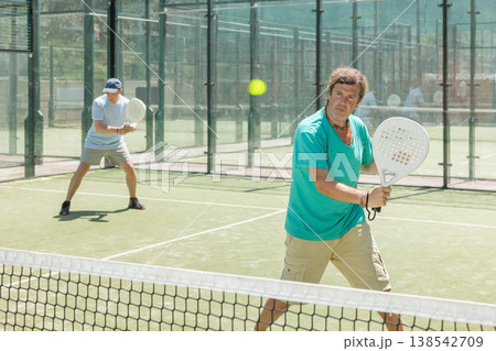 Padel game - man with partners plays on court Padel game - man with partners plays on court 138542709