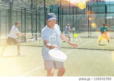 Adult and young men playing padel against two men Adult and young men playing padel against two men 138542769