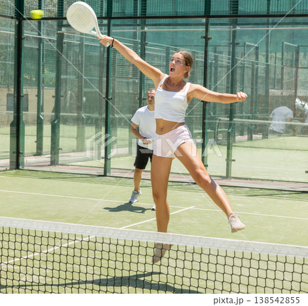 Young woman and man playing doubles padel Young woman and man playing doubles padel 138542855