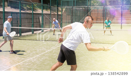 Adult and young men playing padel against two men Adult and young men playing padel against two men 138542899