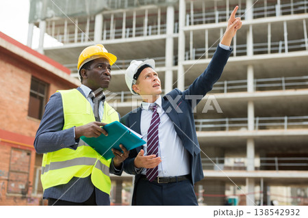 Young architect discusses a construction plan with an engineer 138542932