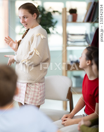 Teenage girl stands in a circle in front of other schoolchildren Teenage girl stands in a circle in front of other schoolchildren 138542934