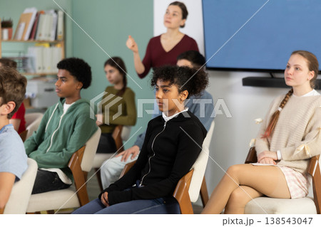 Teenage children sit in the classroom and look at the presentation Teenage children sit in the classroom and look at the presentation 138543047