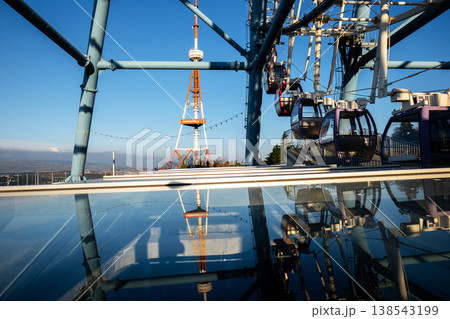 Mirrored glass reflection of amusement park wheel cabins and the iconic red and white TV tower in Georgia 138543199