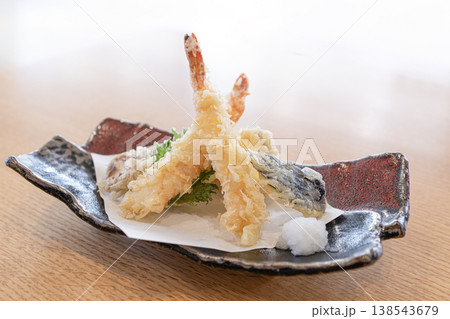 皿に美しく盛り付けられたサクサクの海老と野菜の天ぷら 138543679