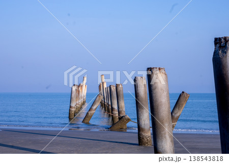 The Leaning pole at Sao Aiang Beach- Derelict concrete pier posts in the seaOld concrete pillars from an abandoned fishing pier, sticking out of the sea 138543818